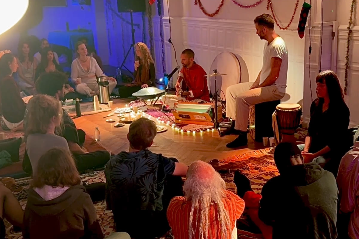 People gathered in a circle around musicians and instruments