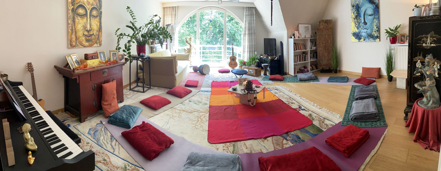 A room prepared for a circle: mats, cushions and a keyboard