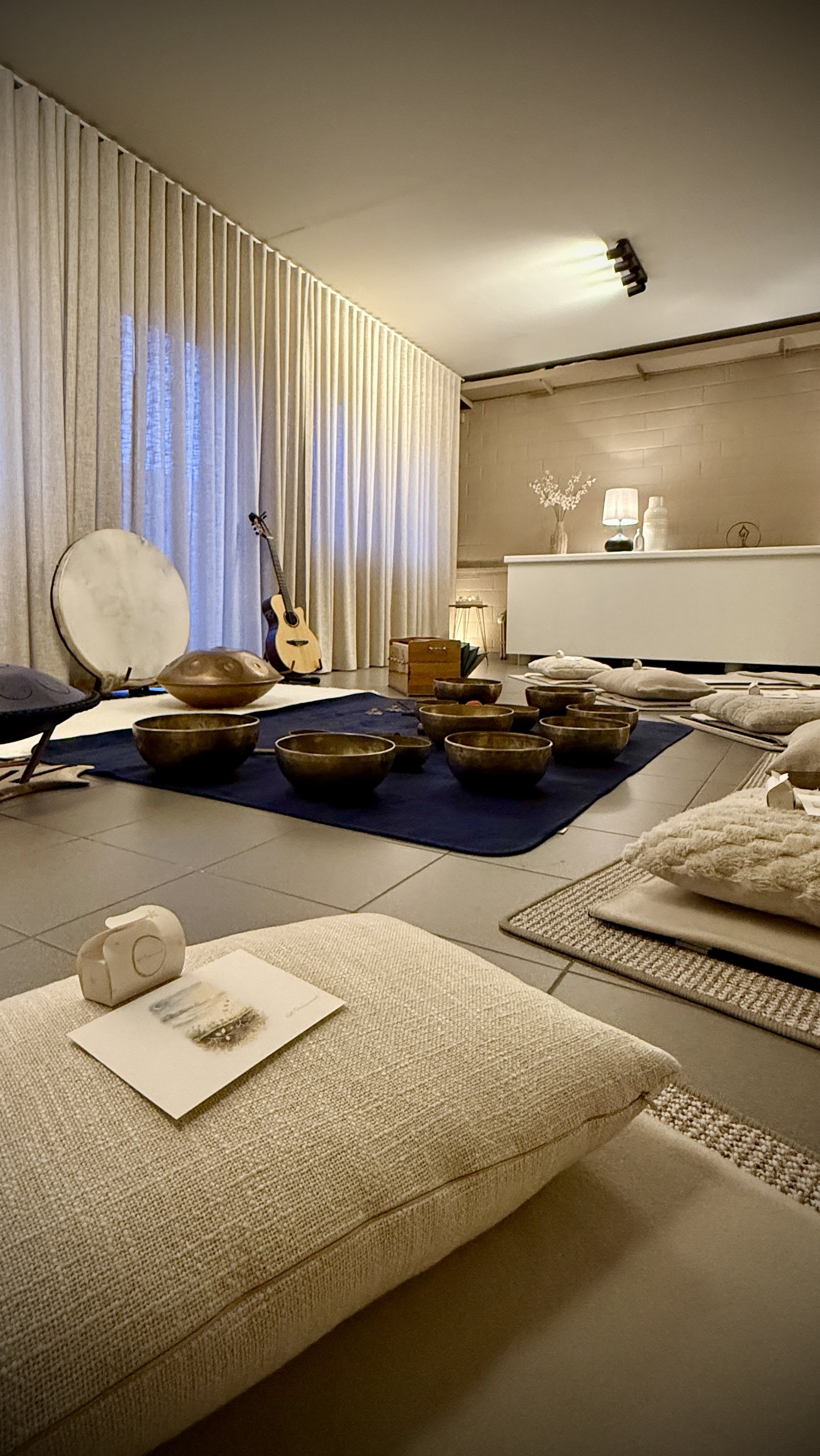A studio space prepared for a sound journey: singing bowls, cushions and instruments laid out